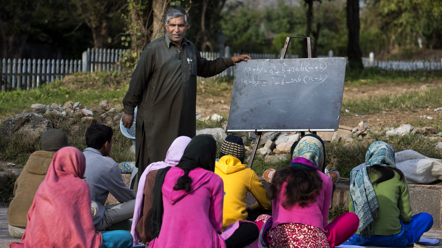 Mohammed Ayub teaches children from slums at his makeshift school in a park in Islamabad, Pakistan, March 12, 2015. Ayub turned a promise to his dying father to make sure his siblings got an education into a life dedicated to teaching the less fortunate of the city. 